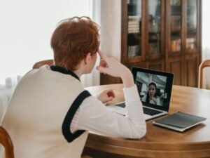 Person on a video call on a laptop using a webcam at a home desk