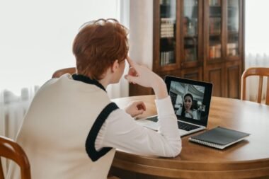 Person on a video call on a laptop using a webcam at a home desk