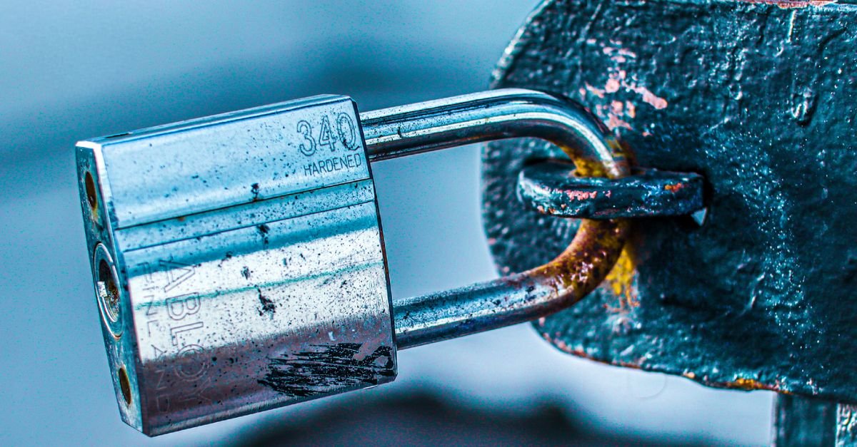 A steel padlock secured on a metal hasp