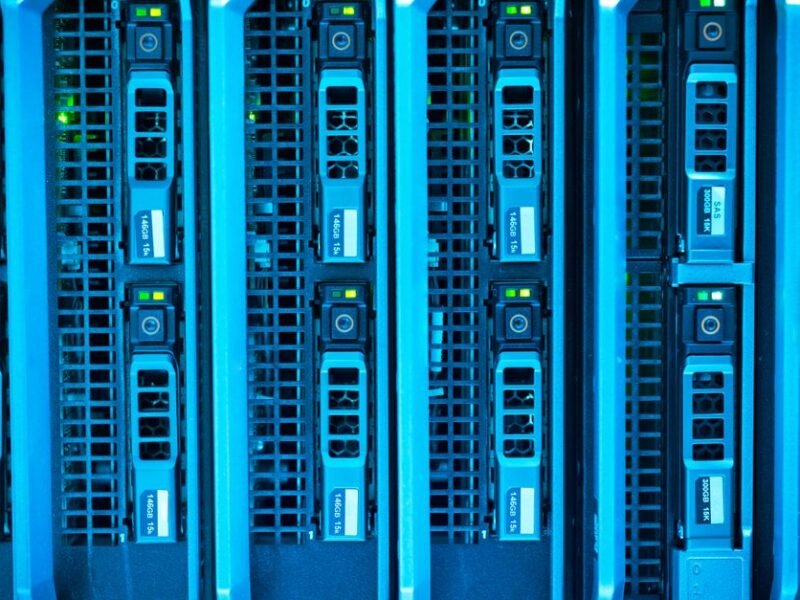 A row of server blades glowing blue in a data center