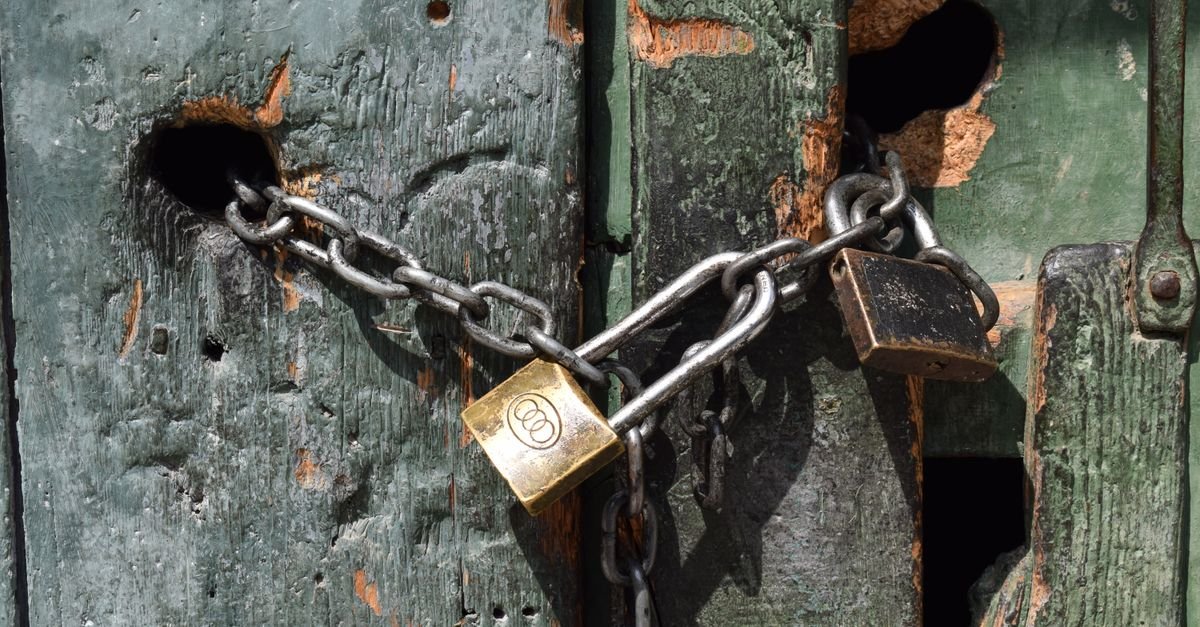 Chained padlocks on a weathered green door