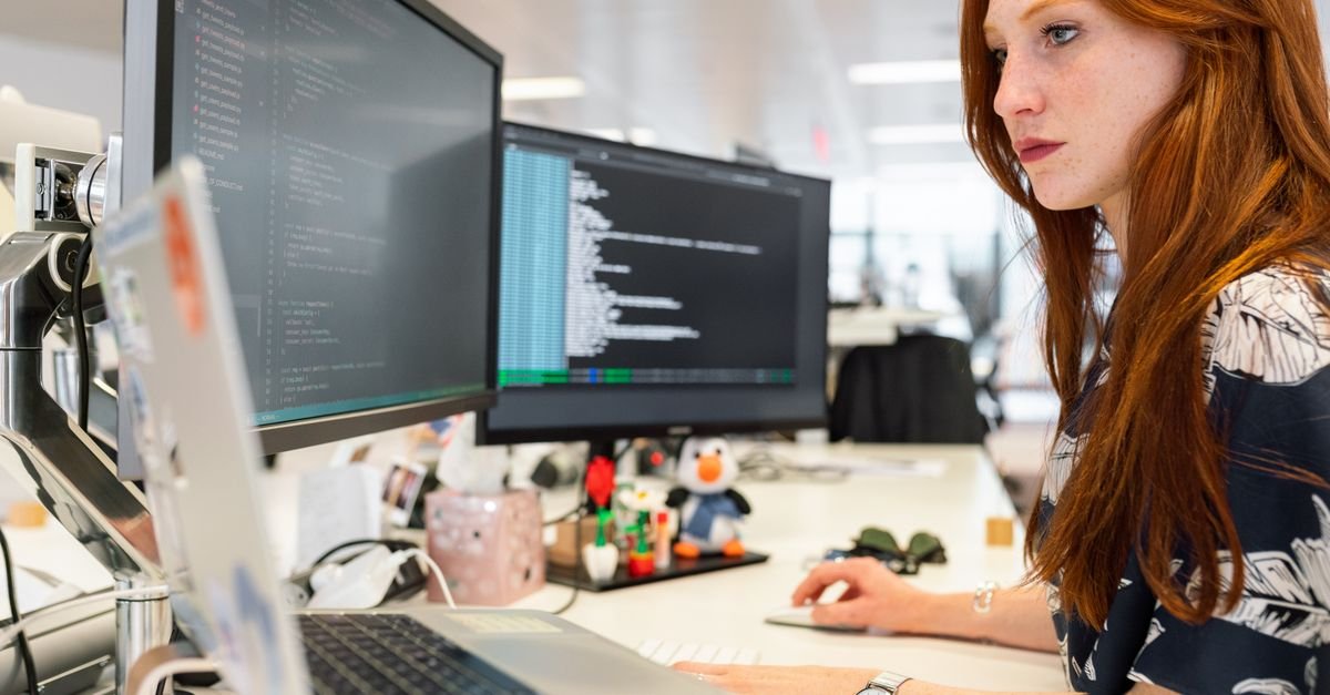 Engineer working across multiple monitors