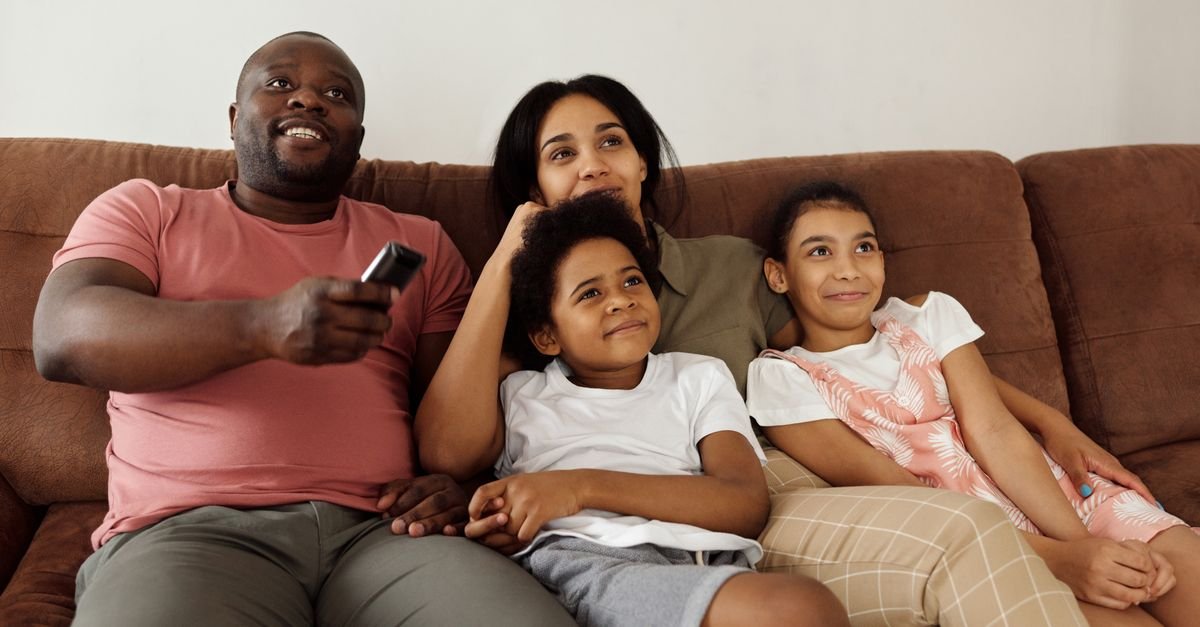 A family streaming a show together on the couch