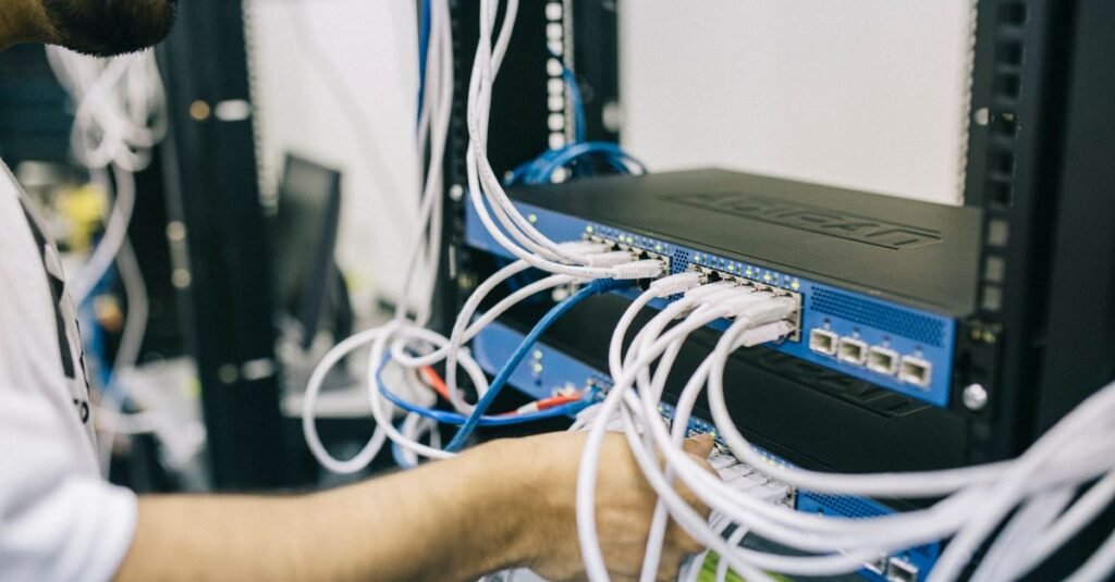 Hands connecting cables on backend server infrastructure