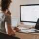 A developer working at a desk with two screens of code