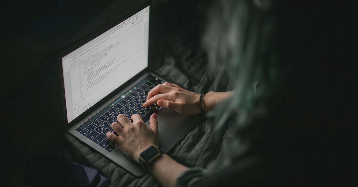 Developer working on a laptop in a dark room