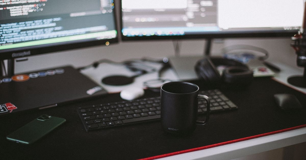 A tidy desk with a monitor, keyboard and coffee mug
