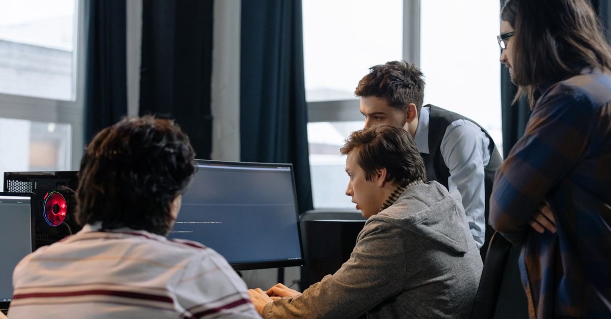 A team of developers collaborating around monitors