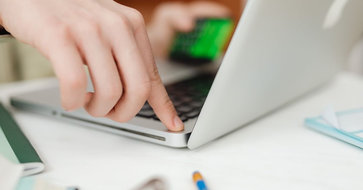 Hands typing on a laptop keyboard