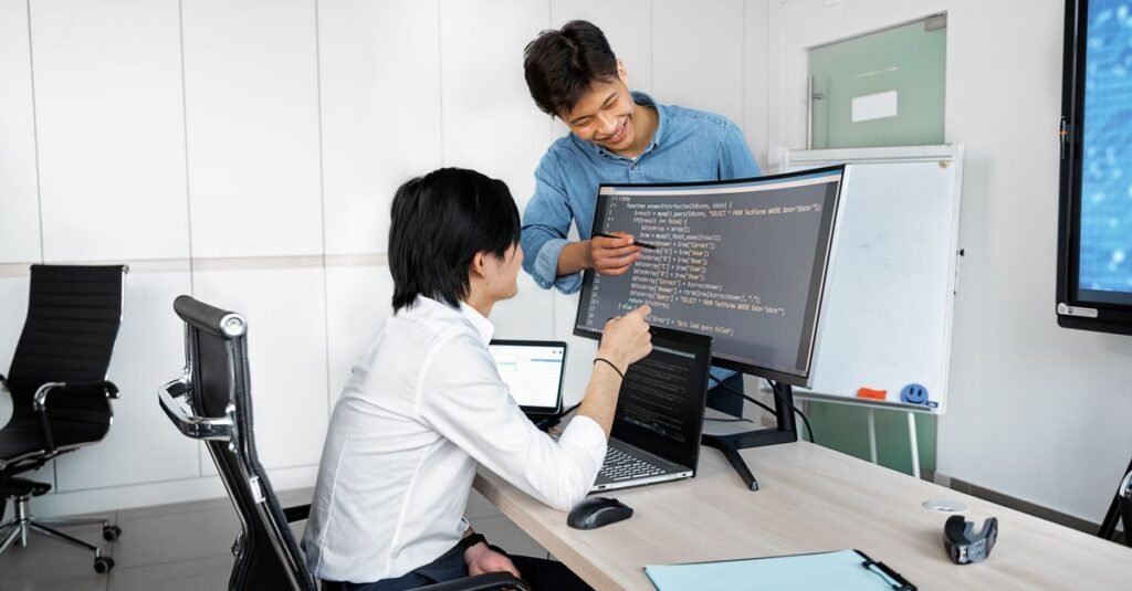 Developers collaborating on a deployment at a workstation