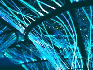 Glowing cyan fiber optic strands against a dark background