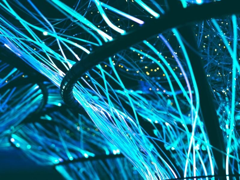 Glowing cyan fiber optic strands against a dark background