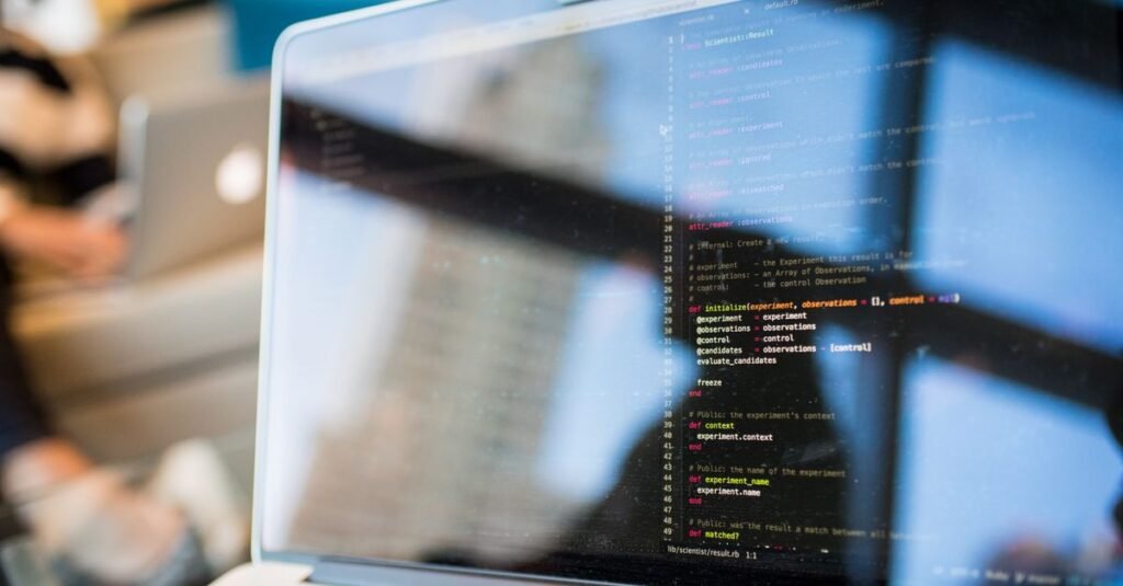 Hands writing code on a laptop