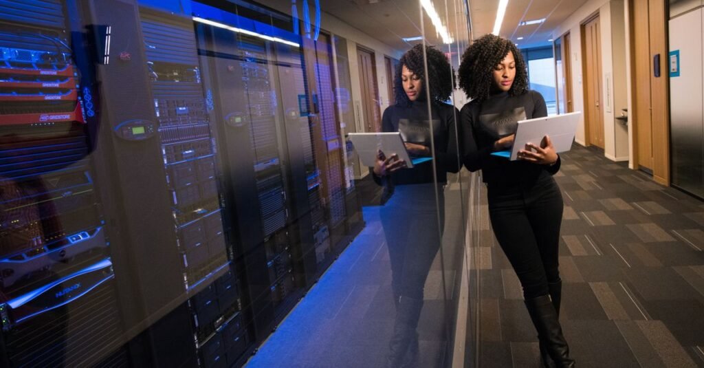 IT professional with a laptop in a server hallway