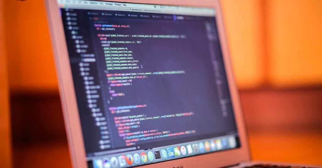 A laptop displaying colorful code