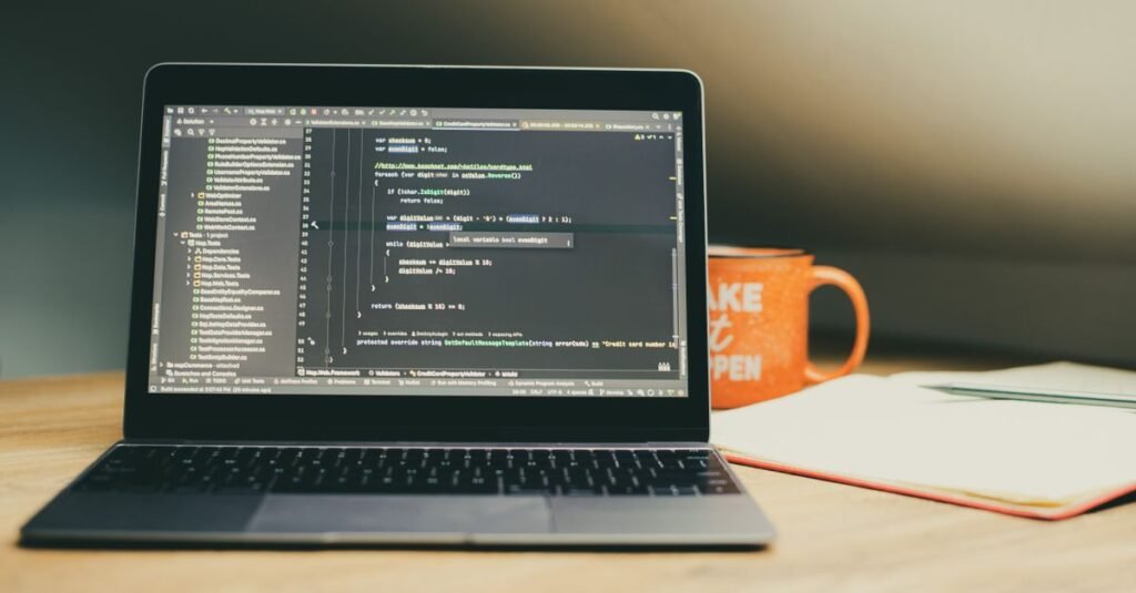 A laptop showing code beside a coffee mug