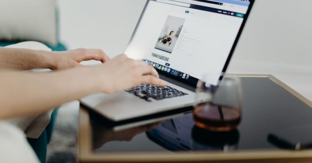 Hands building a website on a laptop