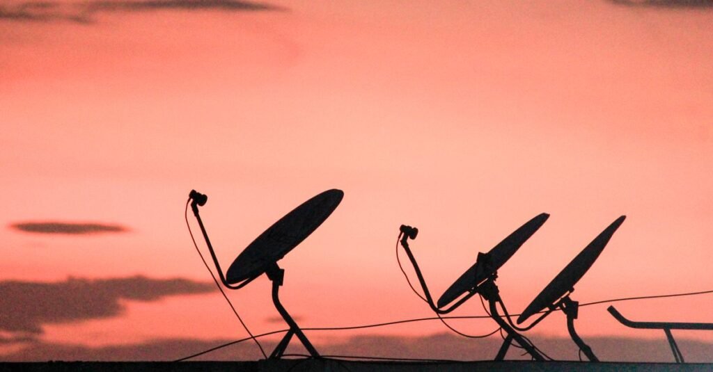 Satellite dishes against an evening sky