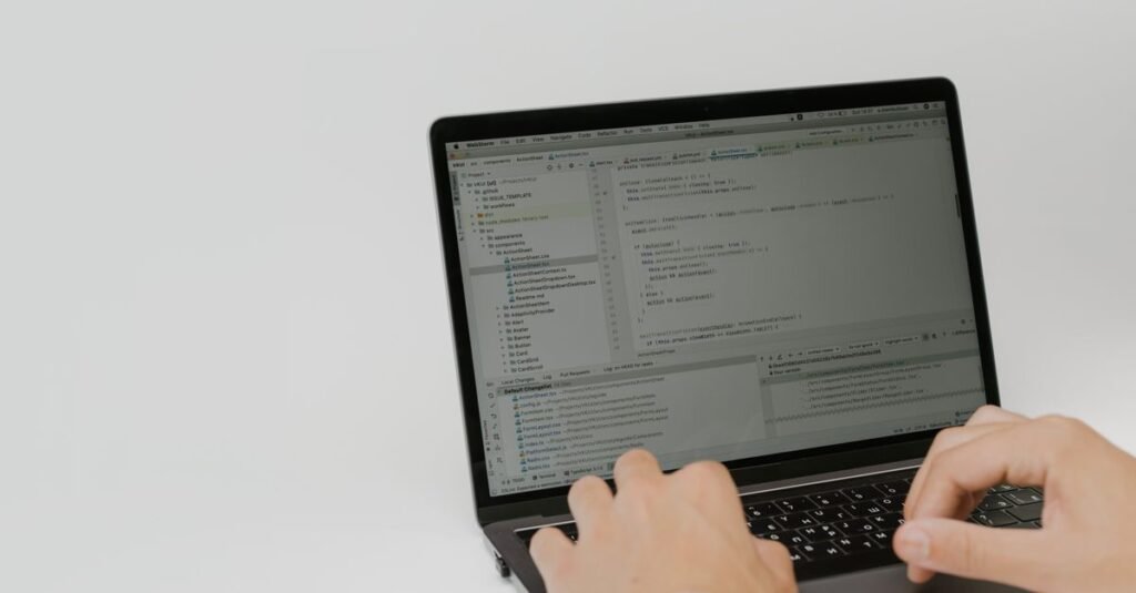 Hands typing code on a laptop