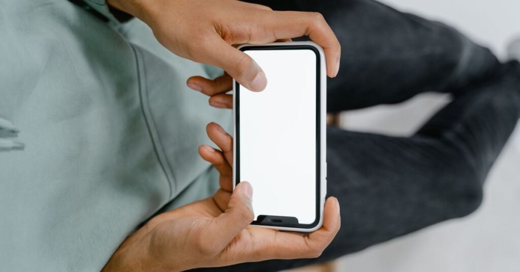 Hand holding a smartphone with a blank screen
